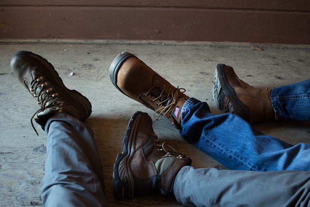 person in blue denim jeans and brown leather boots