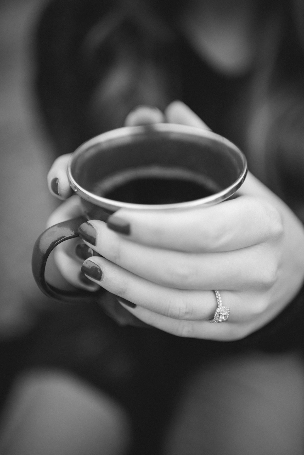 grayscale photography of person holding mug