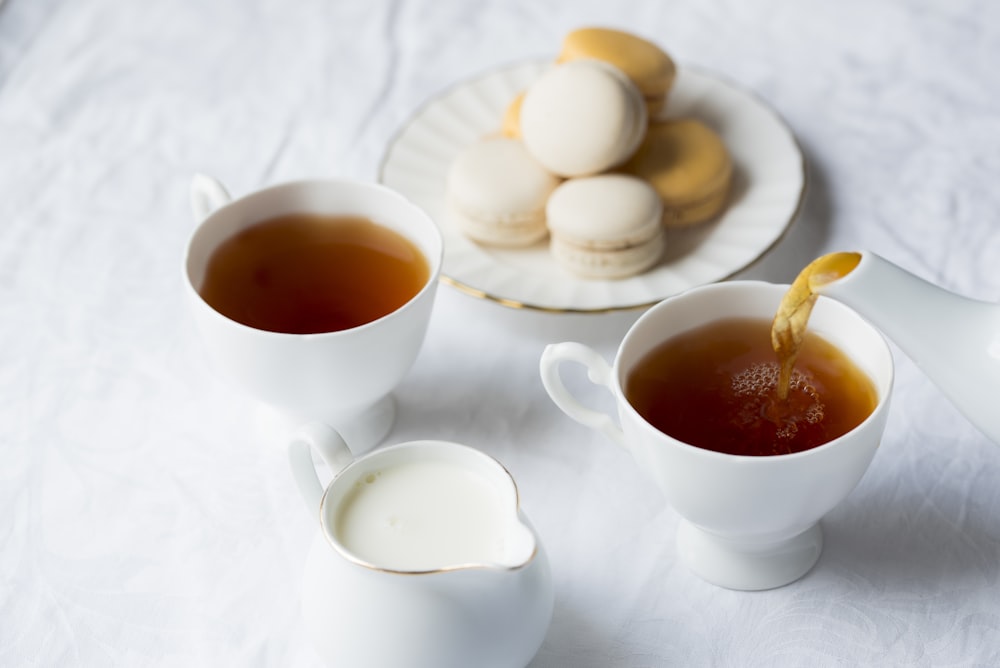 Dos tazas de café junto a los macarrones en el plato