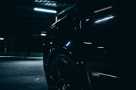 Subtle reflections on the glossy hood of a limousine under ambient showroom lighting.