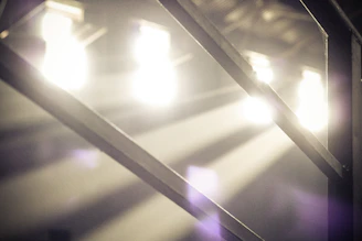 Vibrant portrait with dramatic shadows and hexagonal light patterns framing the subject in an industrial setting.