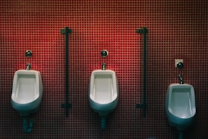 A freshly installed wall-mounted urinal in a modern commercial restroom with clean tile walls