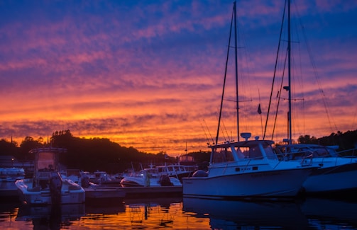 Sunset view over a marina filled with various boats docked peacefully.