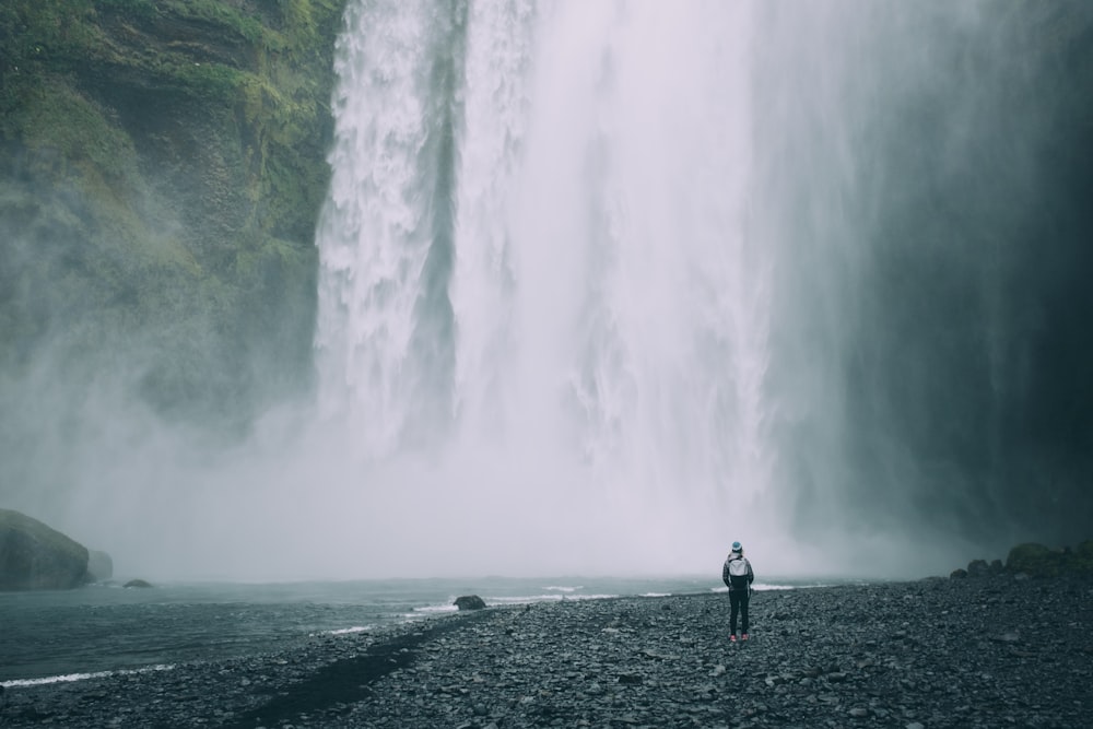person standing near mountain falls