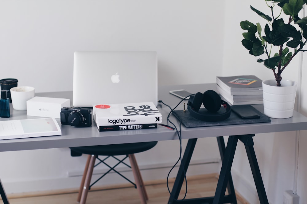 silver MacBook on top of table