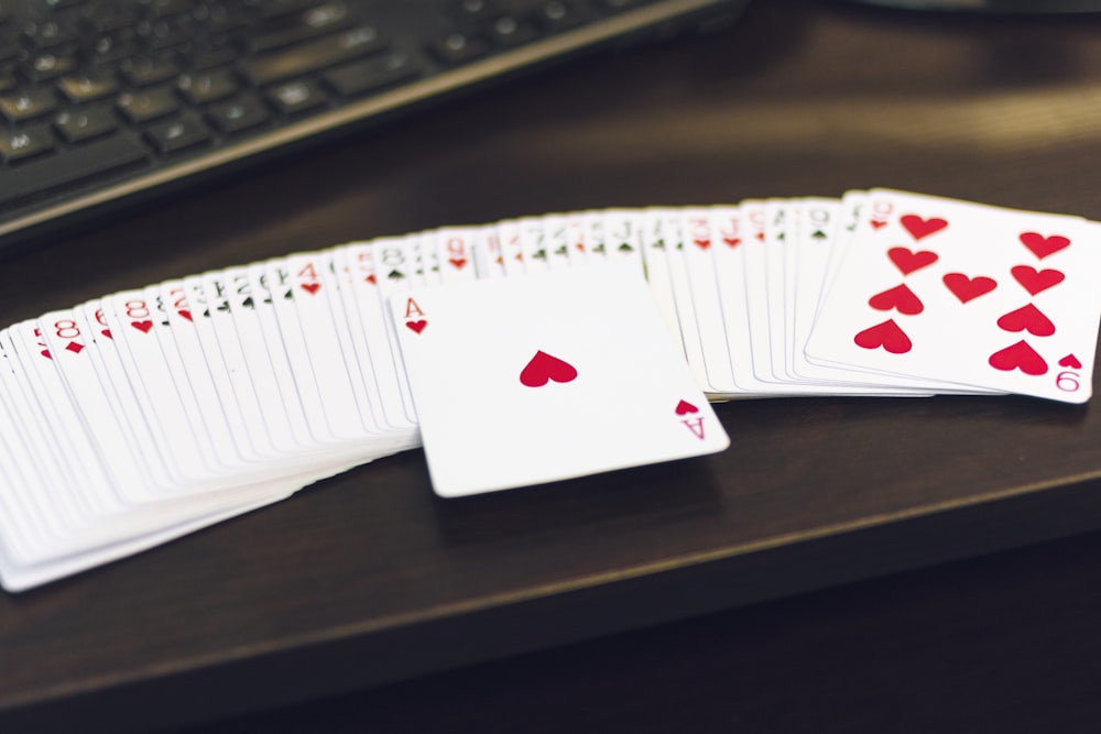 white and red playing cards on white paper