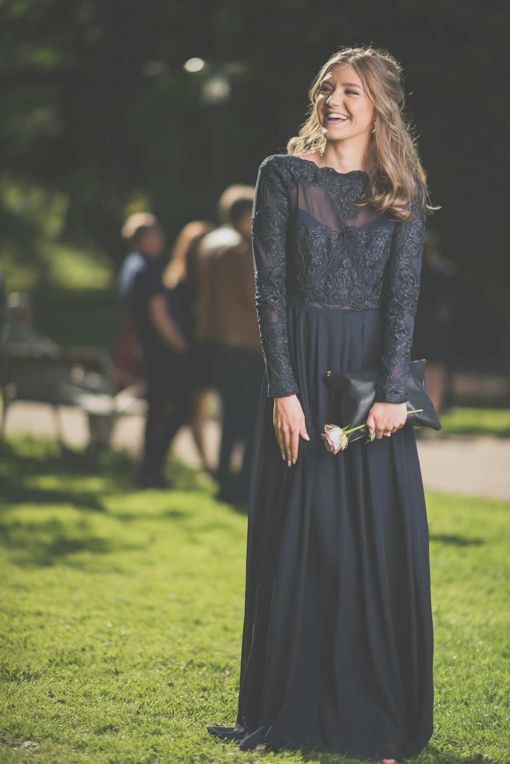 낮 동안 푸른 잔디밭에 서 있는 검은 긴팔 드레스를 입은 여자