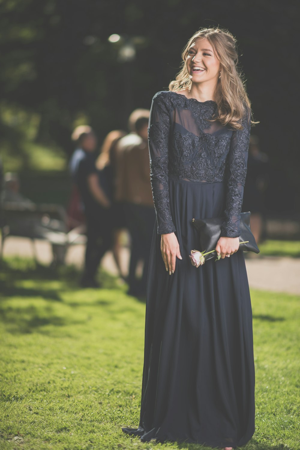 woman in black long sleeve dress standing on green grass field during daytime