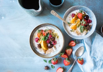 two bowls of oatmeal with fruits