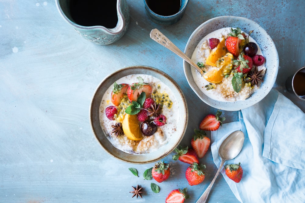 two bowls of oatmeal with fruits