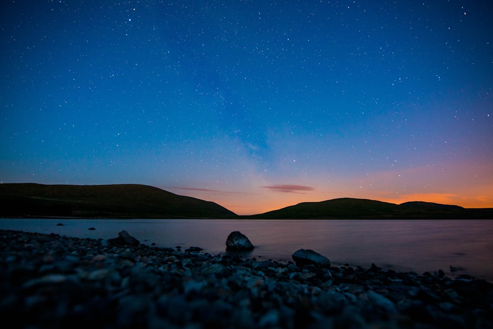 stones on seashore under starry night