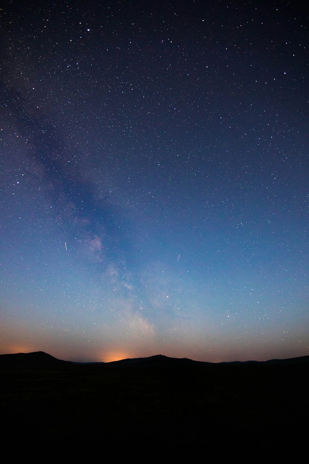 silhouette di terreno montuoso sotto la via lattea