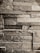 A textured wall made of rectangular stone slabs arranged in a staggered pattern. The stones vary in shade, creating a rustic and natural look.