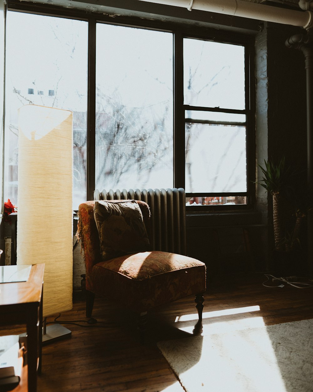 brown fabric chair near beige floor lamp