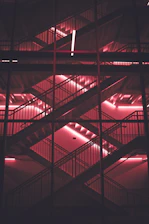 Futuristic digital staircase with glowing pink, tinto, and orange neon lights representing interactive game levels.