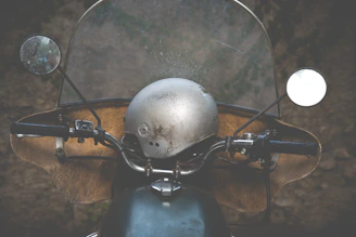 Close-up of a rugged motorcycle helmet resting on a vintage leather seat