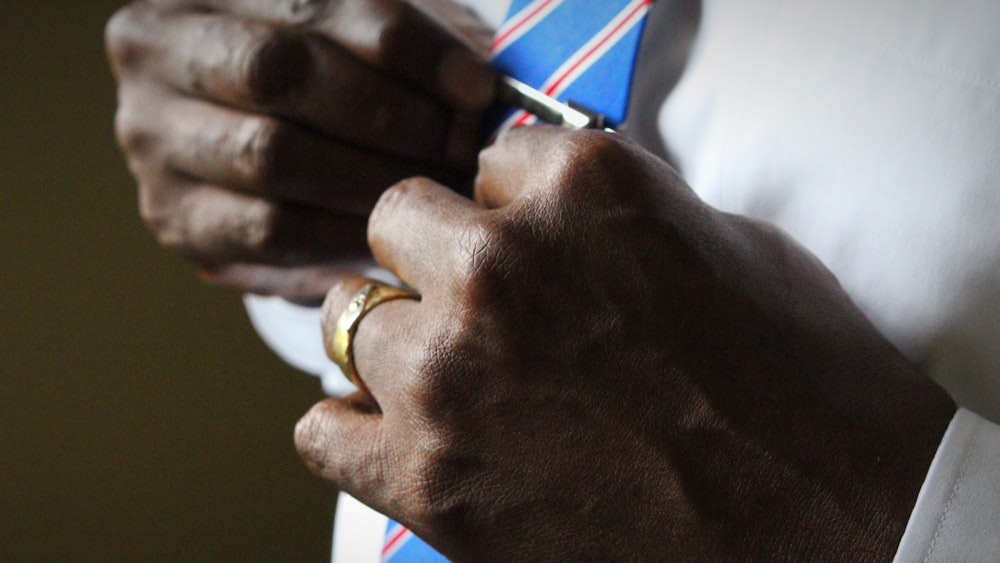 person holding blue necktie