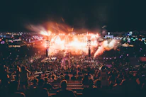 A bustling festival site with coordinated staff managing event logistics under evening lights.