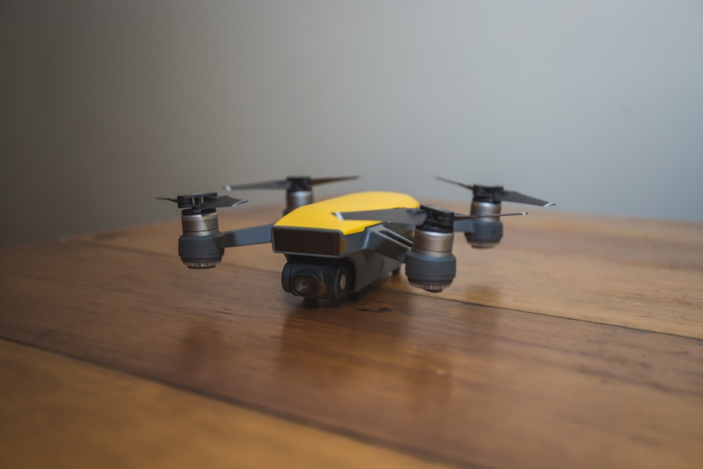 a yellow and black remote controlled flying device on a wooden table