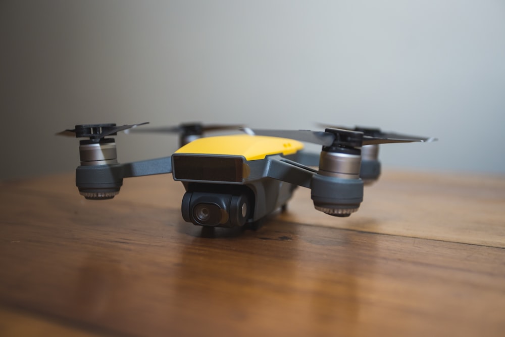 yellow and black DJI drone on wooden surface