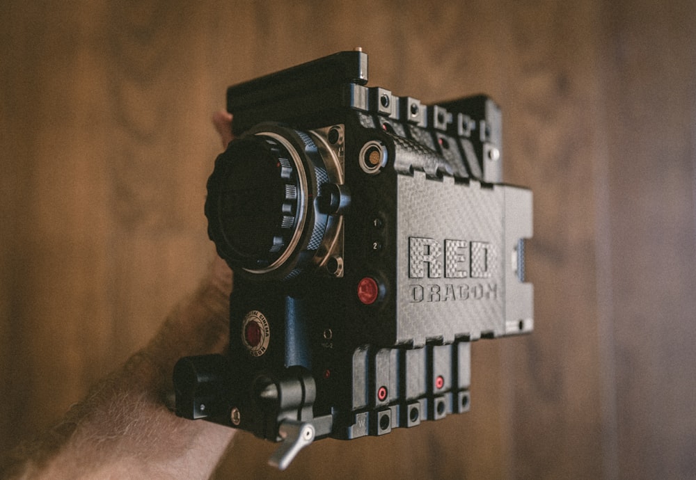 person holding black Red Dragon land camera
