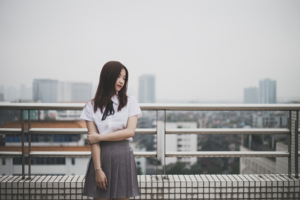 woman wearing white button-up blouse and pleated skirt