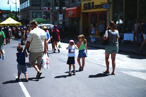 Children playing games and families browsing stalls at a lively community event.