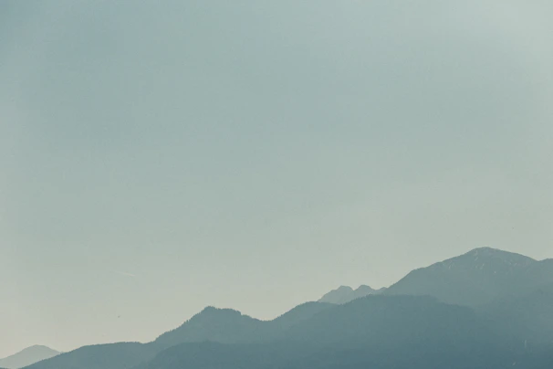 Minimalist shot of a slate grey mountain ridge fading into soft glacier blue mist.