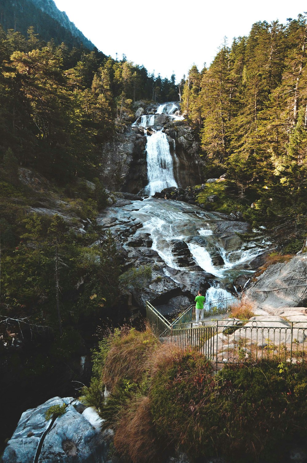 Clôture en métal vert près des chutes d’eau pendant la journée