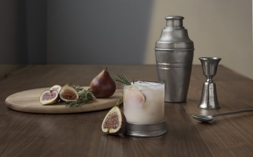 sliced oval brown fruit beside glass cup