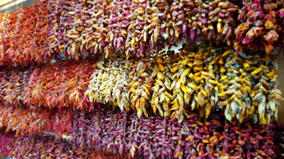 Dried long pepper (pipili) strands displayed on a natural fiber cloth.