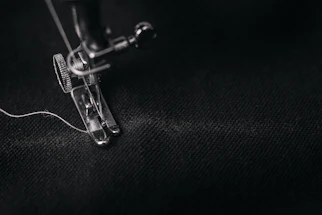 A close-up of a modern sewing machine needle stitching fabric with precision.