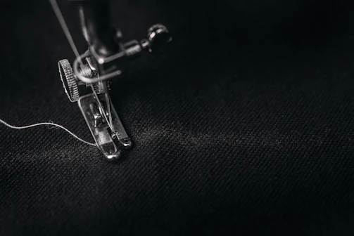 A close-up of a modern sewing machine needle stitching fabric with precision.