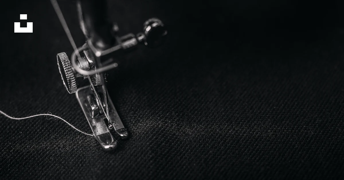 Photo of gray sewing machine foot lock with thread on black cloth photo ...