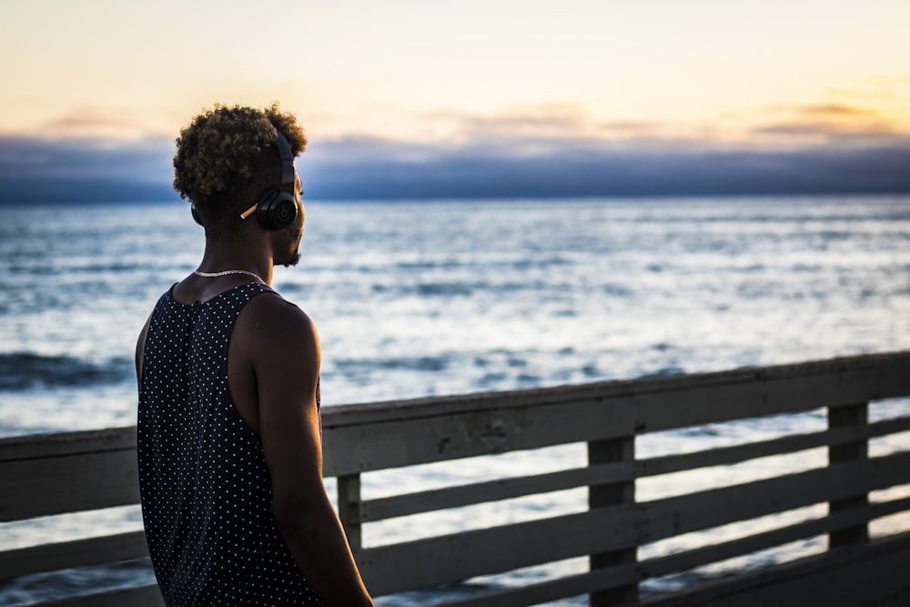 man walking on dock facing ocean