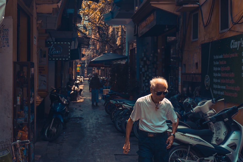 man wearing white shirt beside the motorcycle