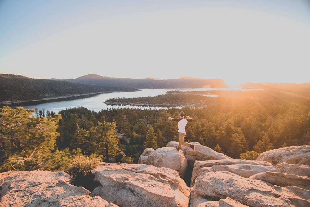 man jumping on rocky mountain golden golden hour