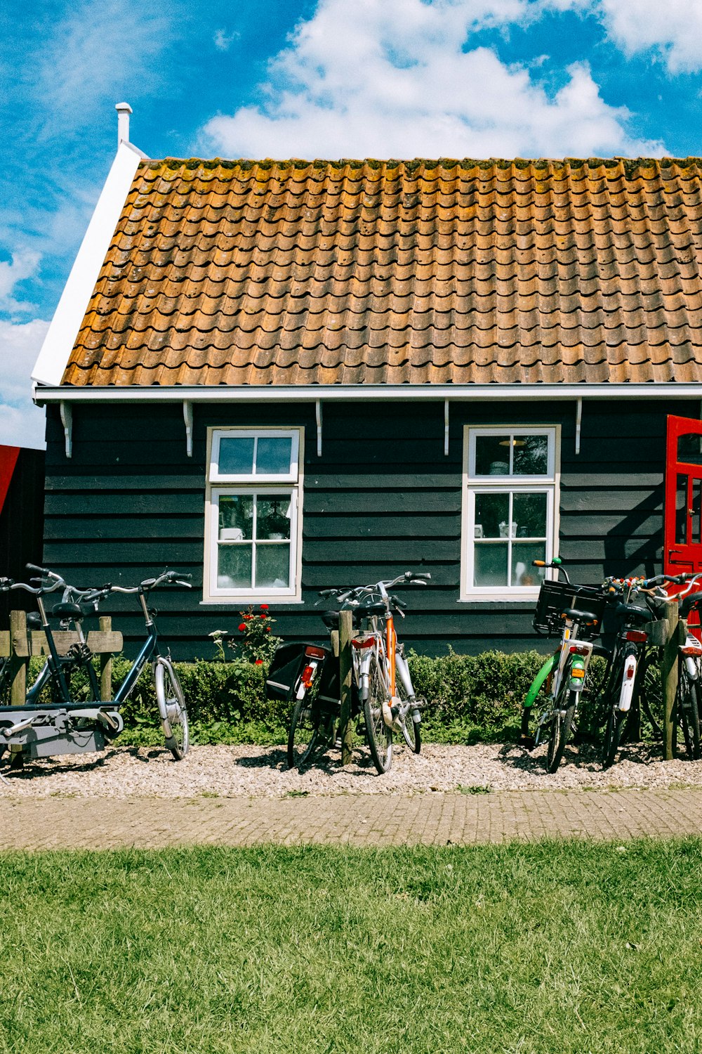 black and gray mountain bikes parked beside red and white house