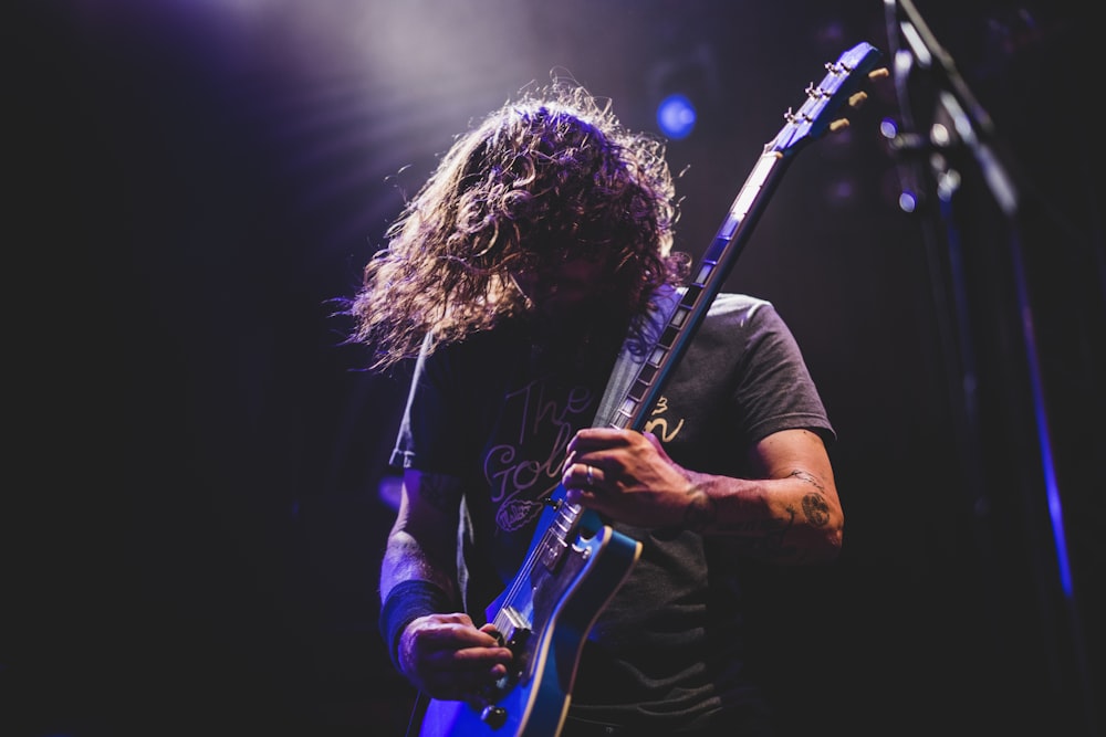 homme jouant de la guitare électrique