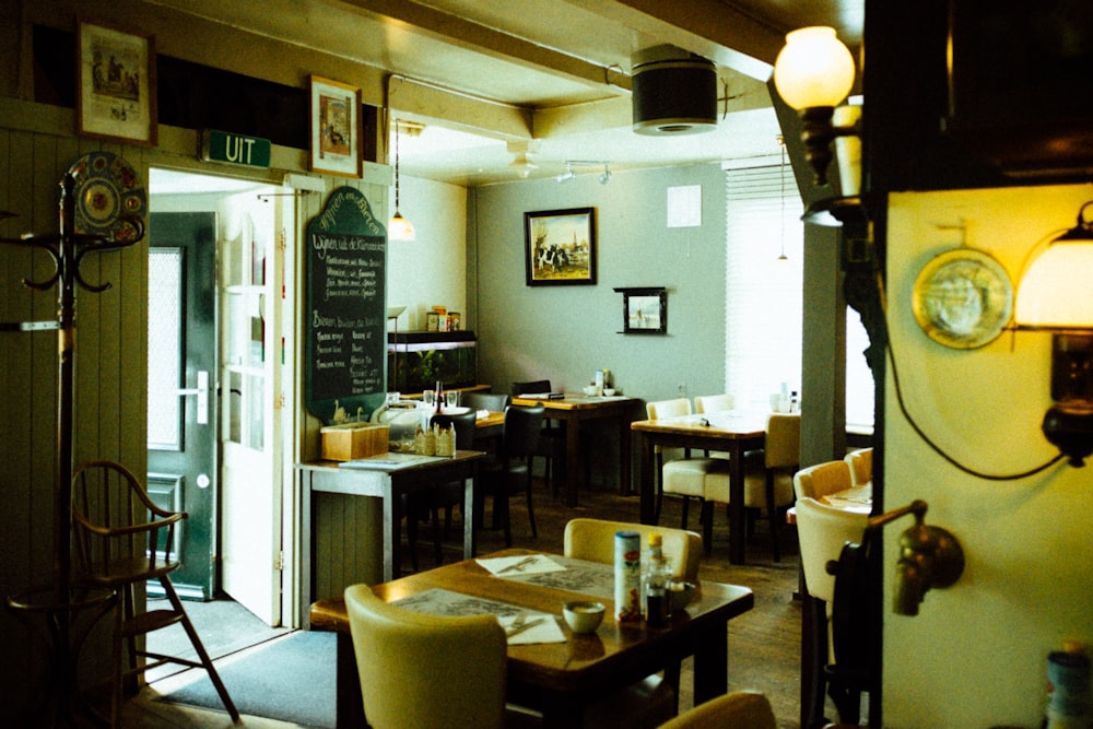 a restaurant with tables, chairs, and a chalkboard