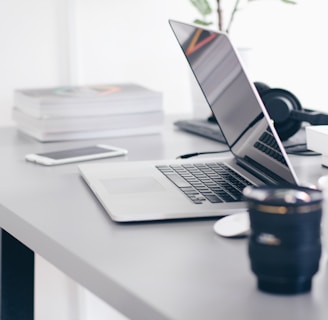 silver MacBook Pro on white table