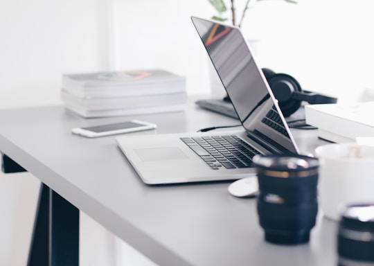 silver MacBook Pro on white table