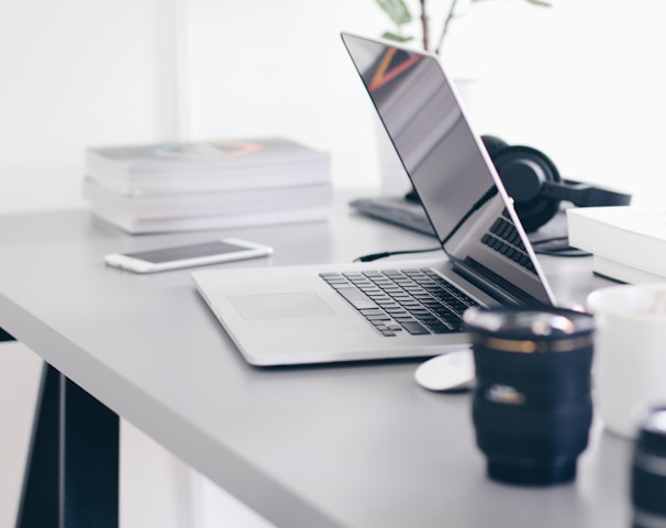 silver MacBook Pro on white table