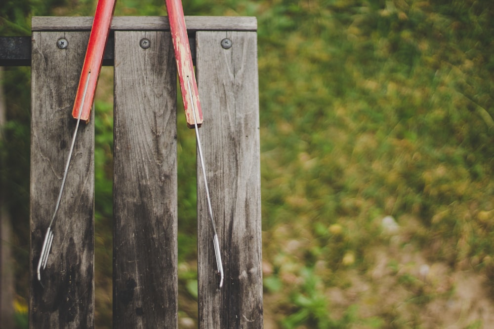 Pinza gris y roja sobre banco de madera