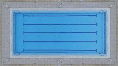 Close-up drone image of a swimming pool with turquoise water and elegant deck.
