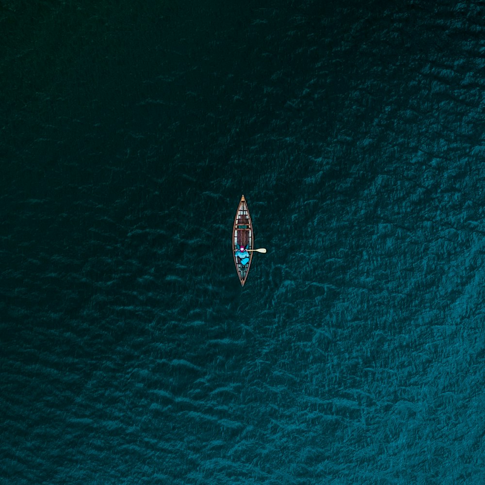 Fotografía aérea de una persona montando un barco en el cuerpo de agua