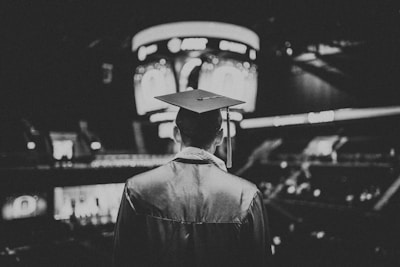 man in academic dress wearing mortar cap