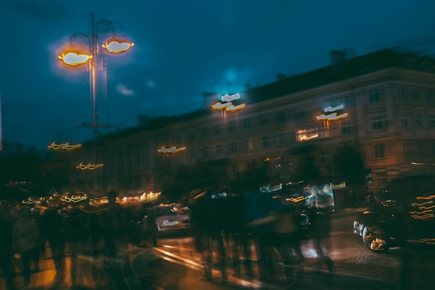 Warm-toned nighttime cityscape with glowing streetlights and blurred taxi lights.