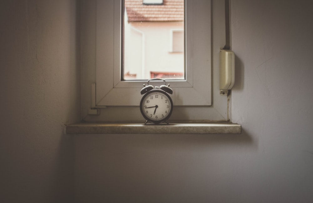 white alarm clock on window still