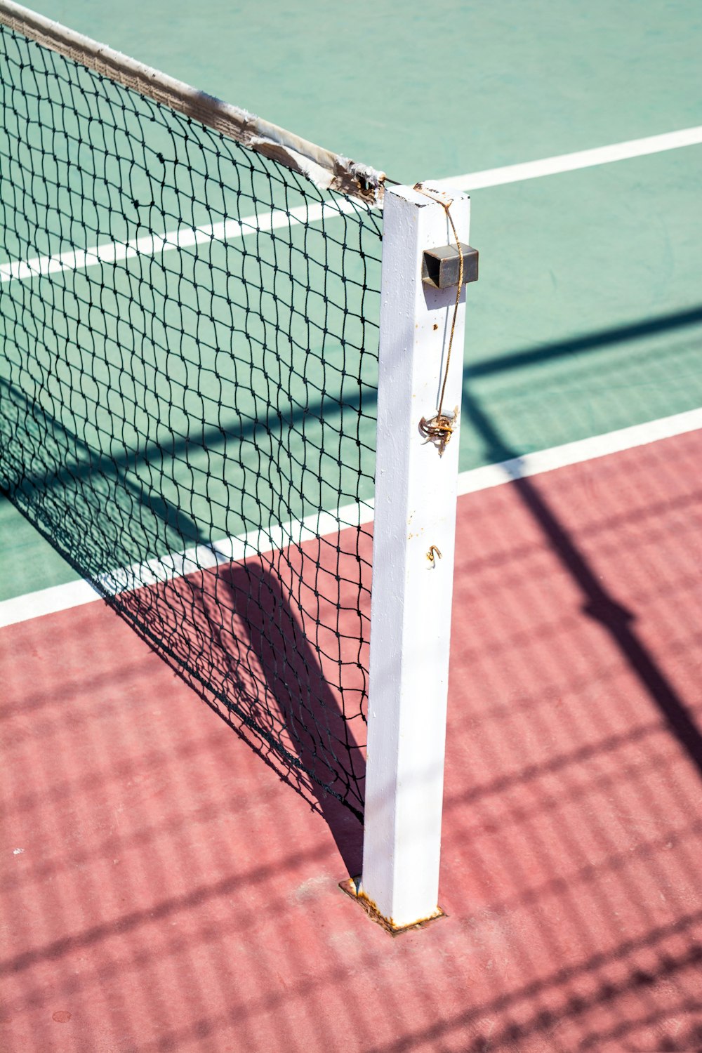 Eine fokussierte Aufnahme eines Pfostens auf einer Seite eines Tennisnetzes.